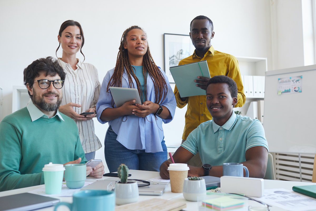 Coworkers sitting together and smiling outside. Coworkers sitting together and smiling outside.